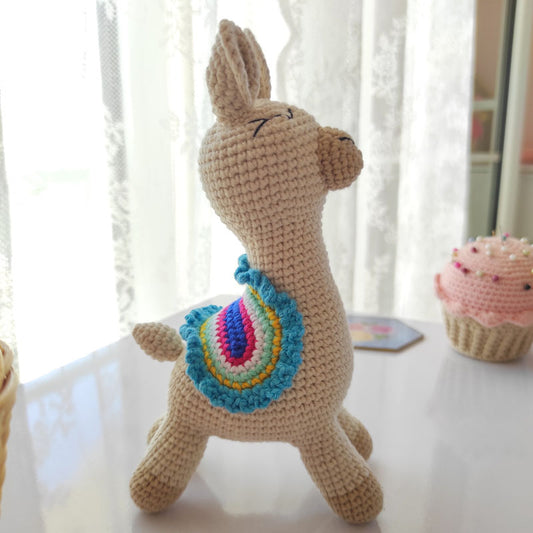 Πλεκτό κουκλάκι μπεζ αλπακά (llama) με πολύχρωμη σέλα, ύψος 19εκ